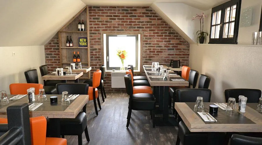 Salle du restaurant Midtown, fauteuils orange et mur de briques